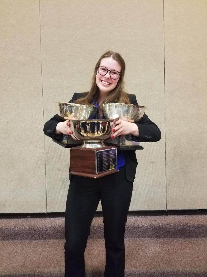 Kinder holds multiple trophies that she has won for debate.